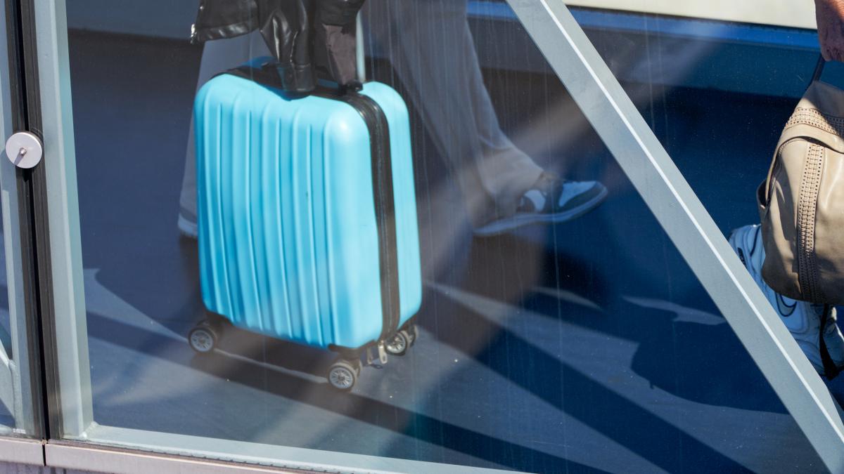 un pasager cu un geamantan la aeroport