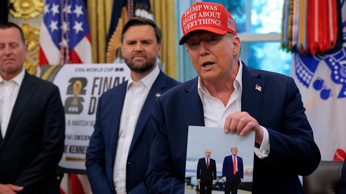 Donald Trump arată o poză cu el și Vladimir Putin.