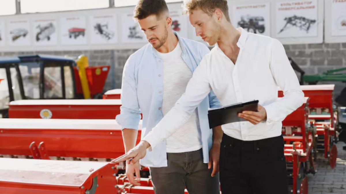 barbati care se uita la un utilaj agricol