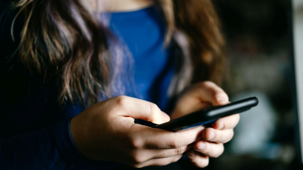 fata care tine un telefon in mana