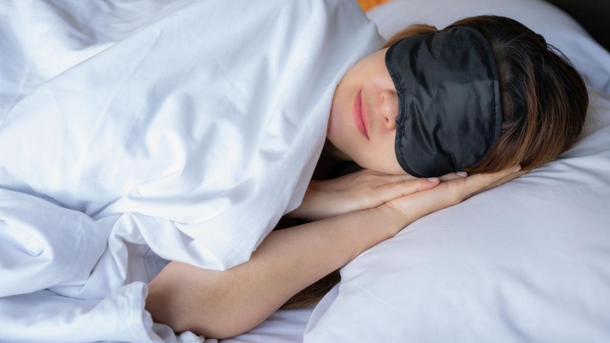 femeie care doarme pe un pat de hotel