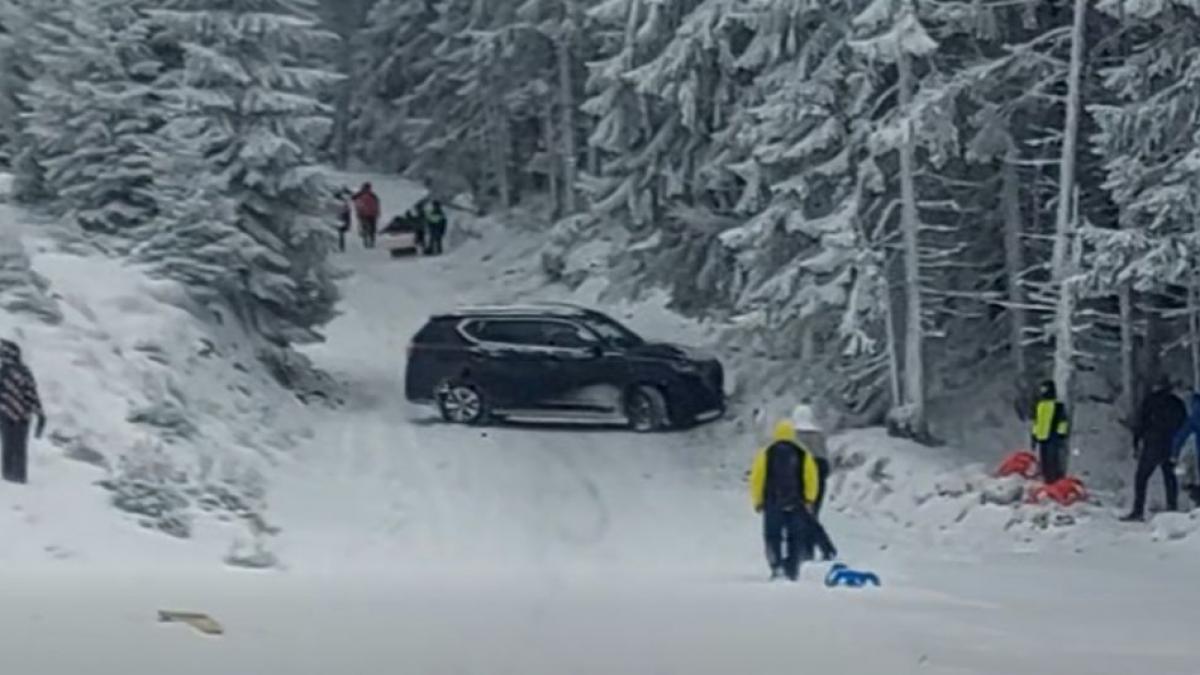 Momentul în care un turist intră cu maşina pe pârtia din Parâng, printre copiii care se dădeau cu sania