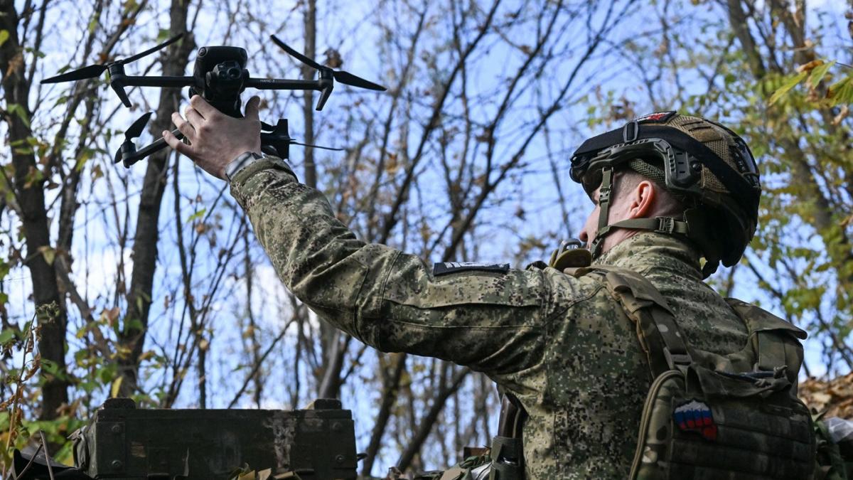 soldat rus care lanseaza o drona de mici dimensiuni