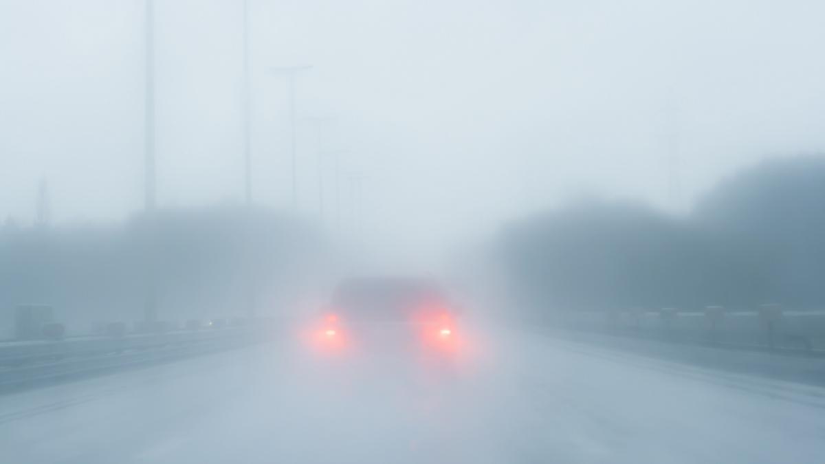 poza in care apare o masina pe un drum, in vreme de cod galben de ceata
