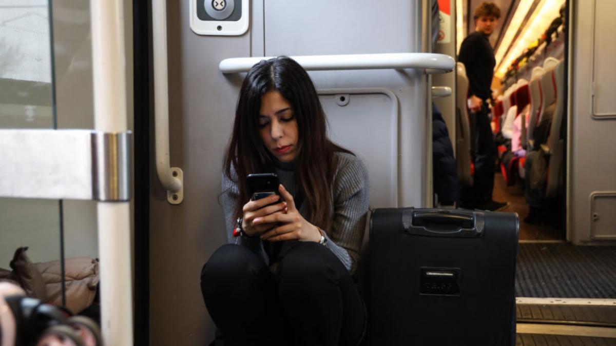 femeie tren calatori bagaje coridor telefon mobil