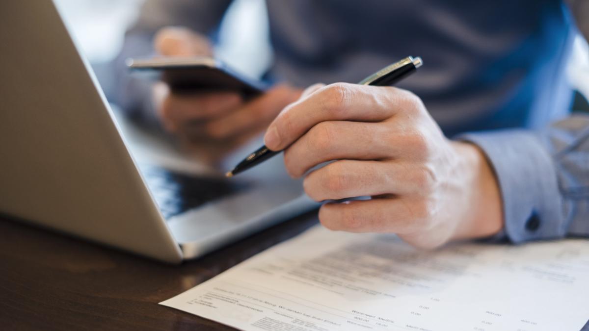 bărbat la birou, cu laptopul în fata 