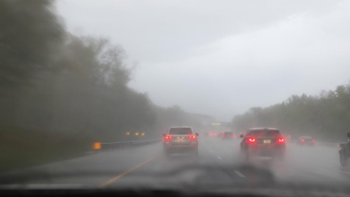 poza in care apar masini pe un drum in timp ce ploua si este ceata