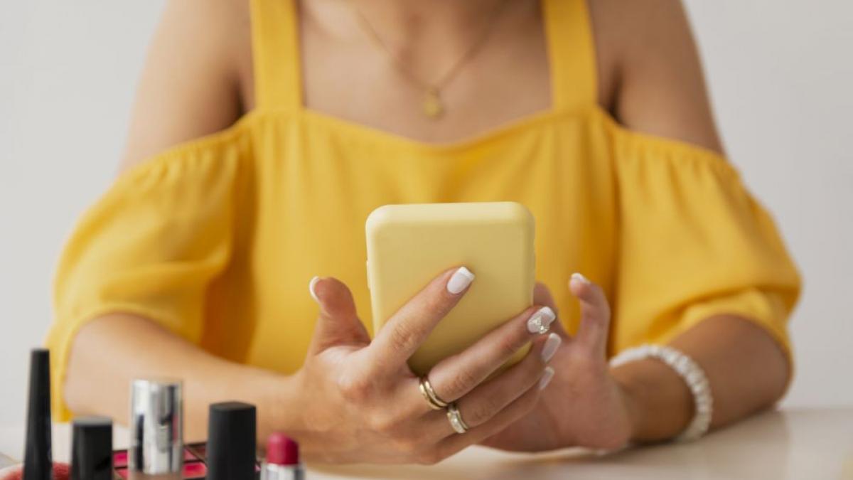 femeie folosind telefonul mobil in timp ce este la manichiura