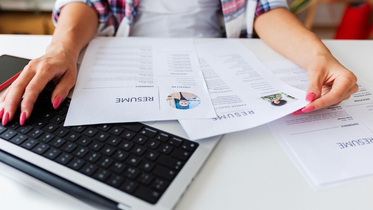 o femeie verifica doua CV-uri  