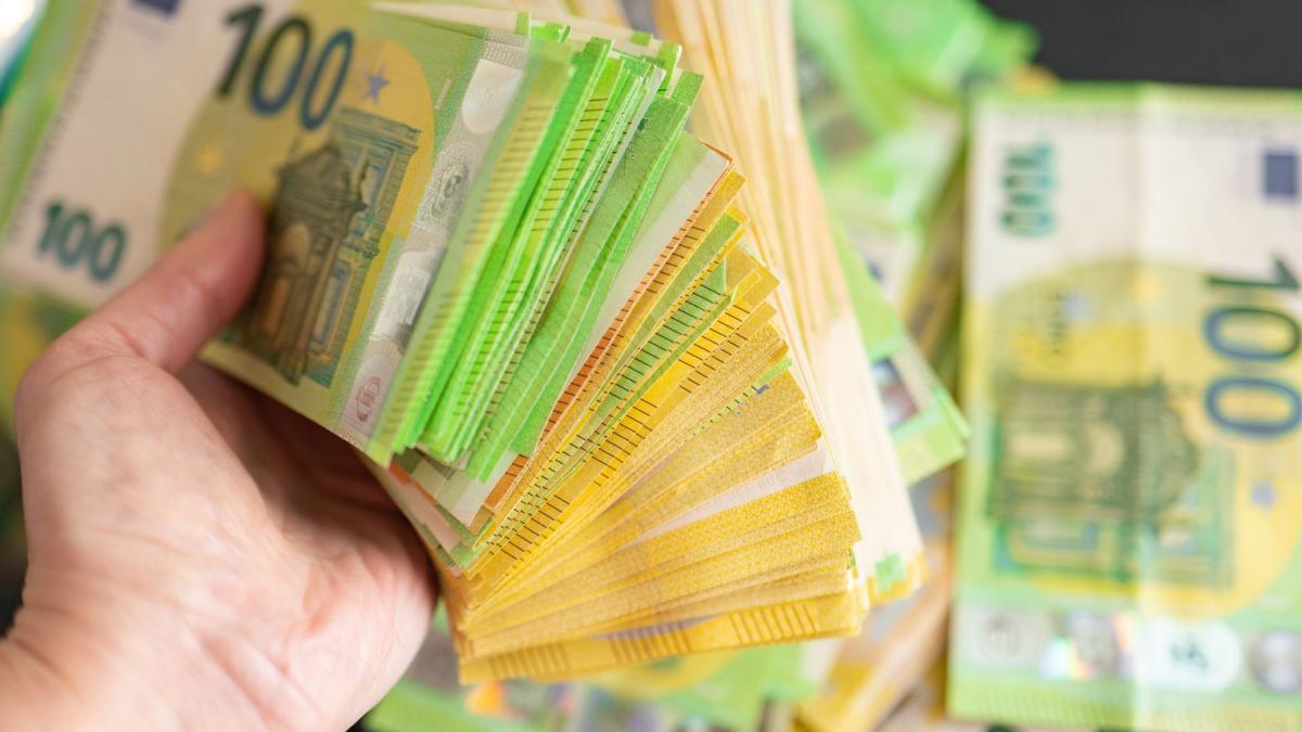 un barbat care tine multi bani in mana