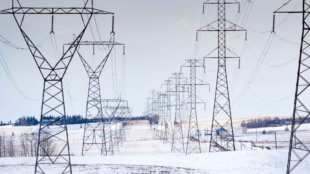 stalpi de inalta tensiune pe un camp iarna