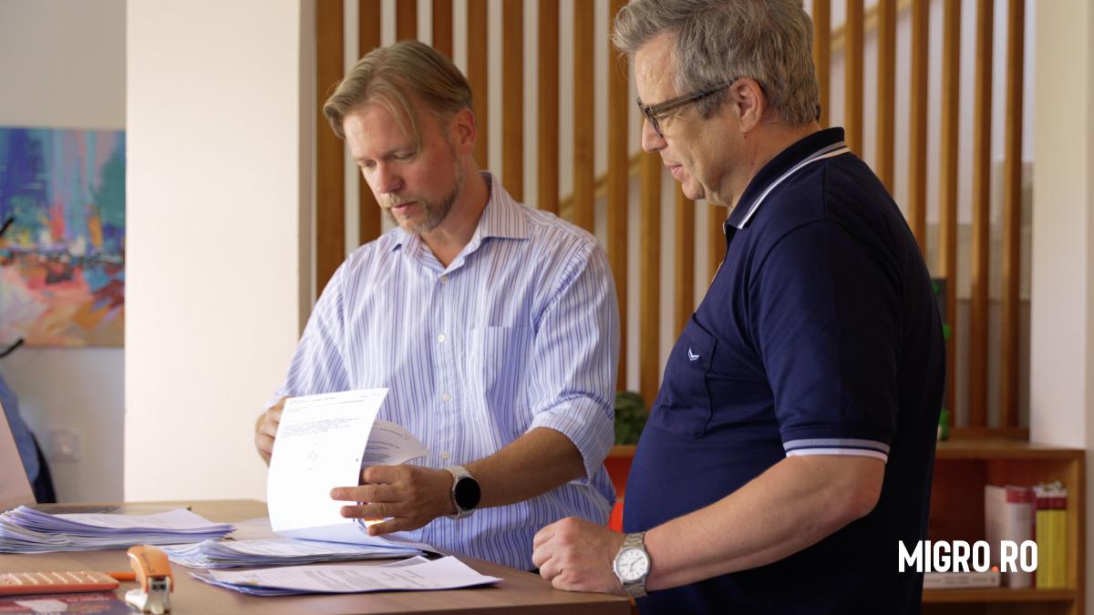 doi barbati se uita pe niste documente