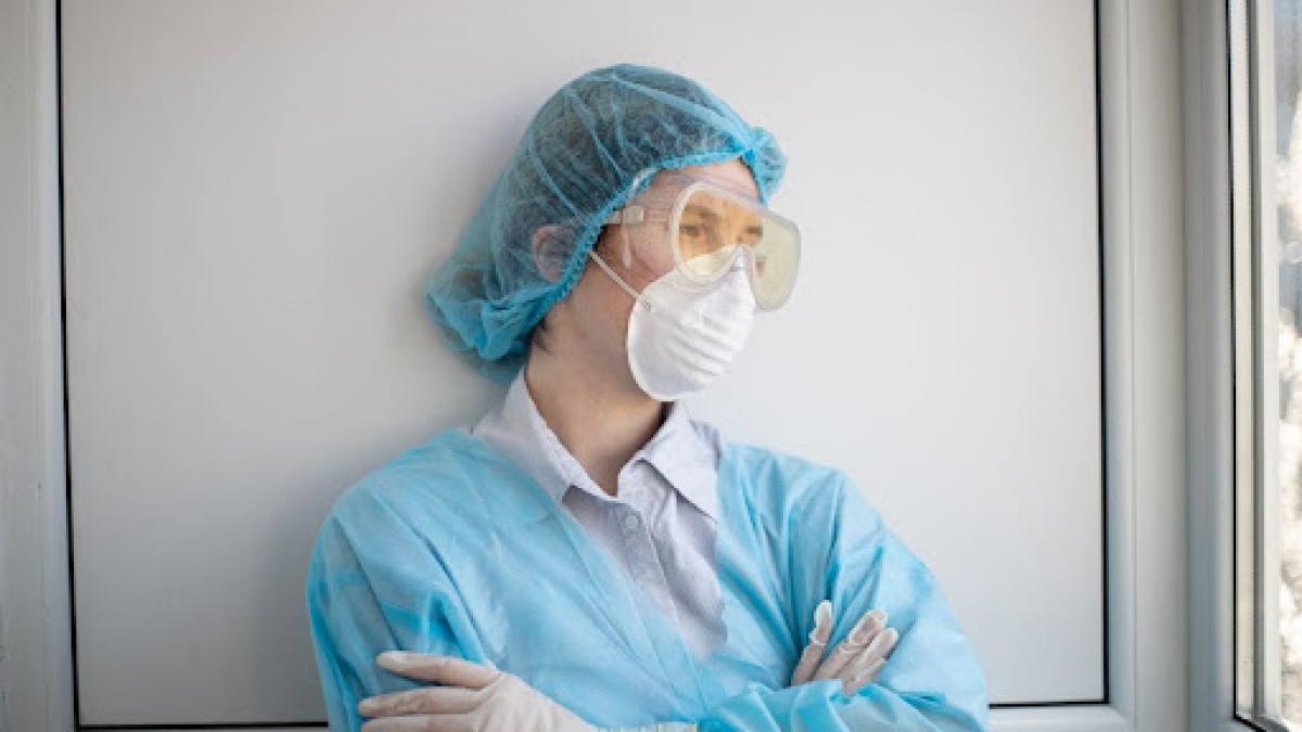 femeie cu masca si combinezon