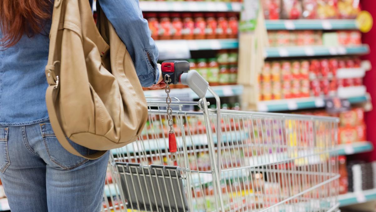 femeie cu cos de cumparaturi in magazin