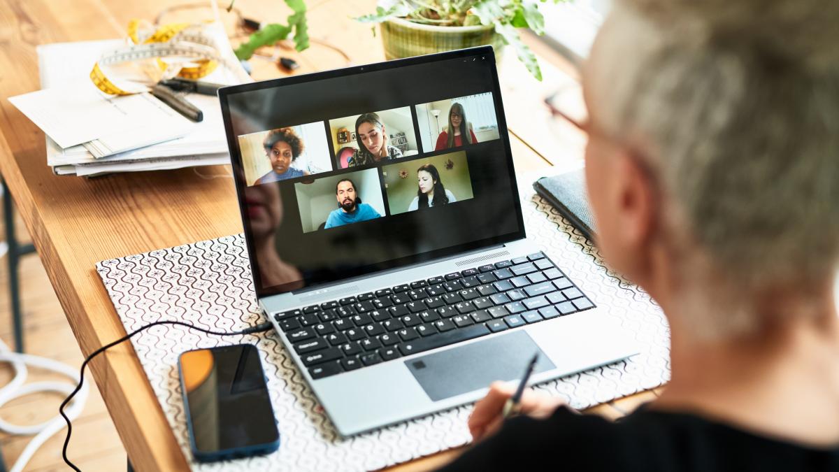 O femeie se afla in fata computerului si sta de vorba cu mai multe persoane