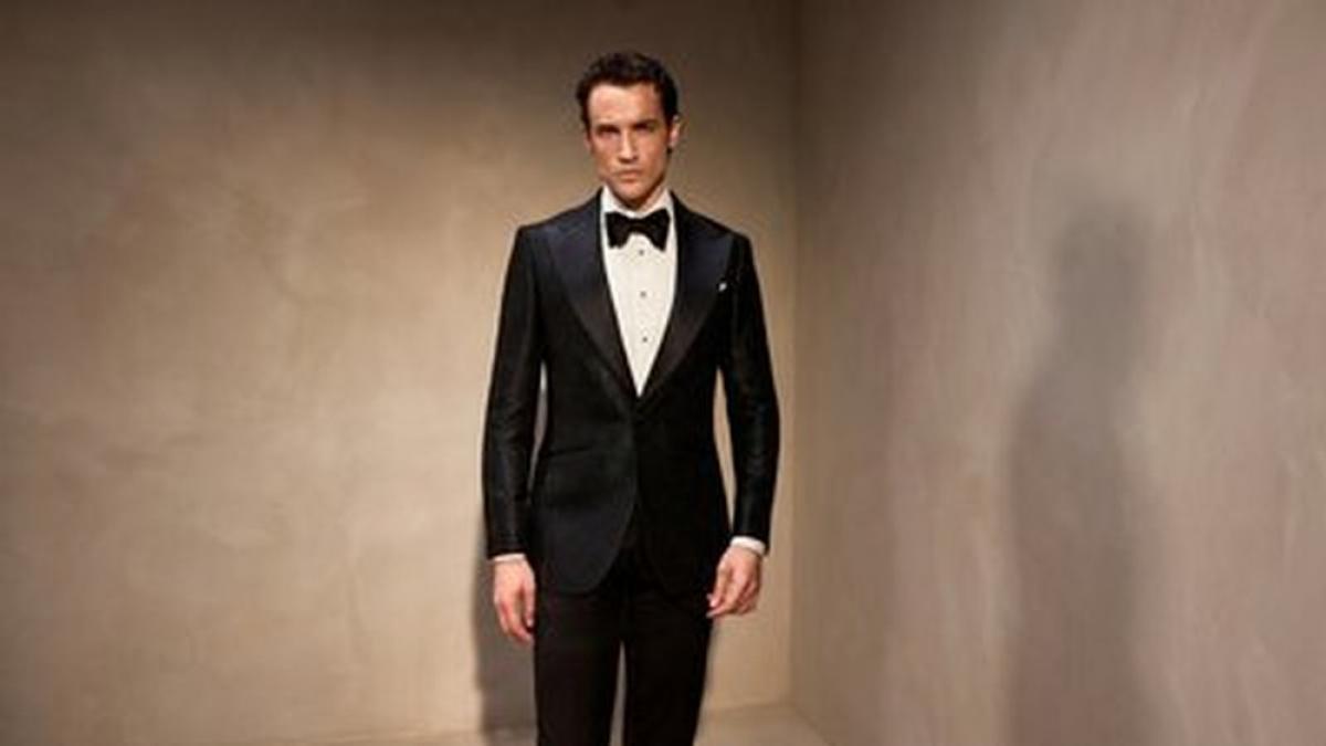 barbat imbracat la costum negru cu papion