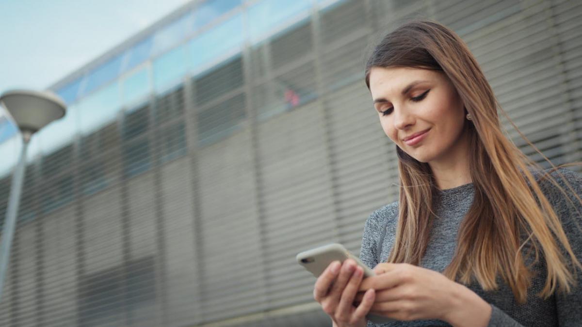 femeie uitandu-se pe telefon