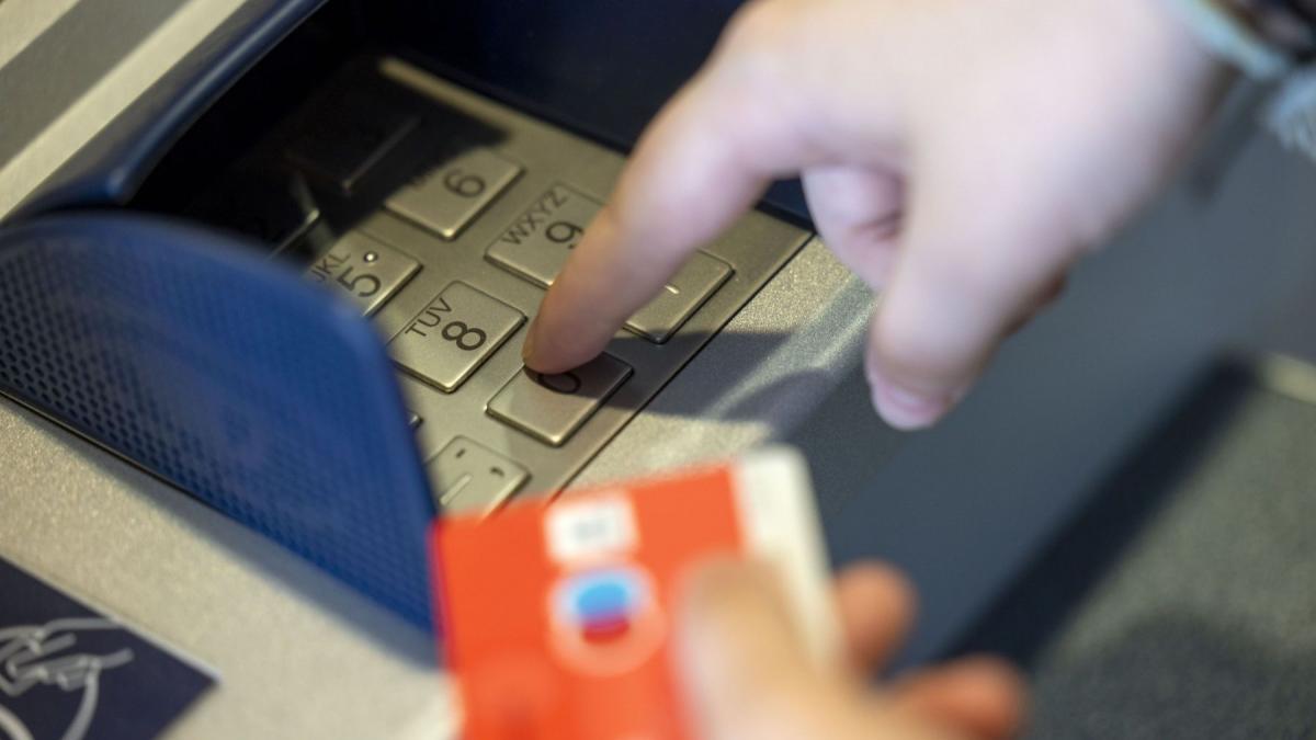 o persoana foloseste un bancomat