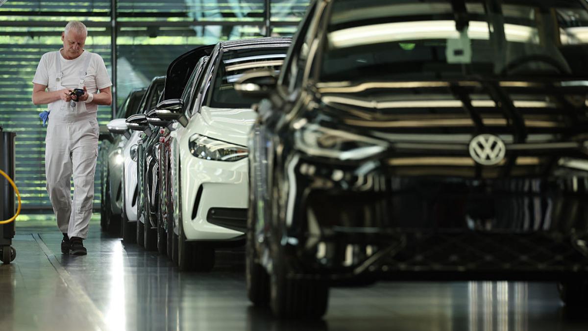 mașini volkswagen și un bărbat în alb care merge printre ele