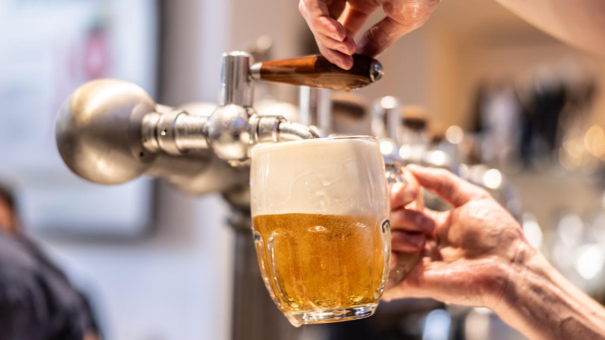 un barbat toarna bere de la dozator într-o halba