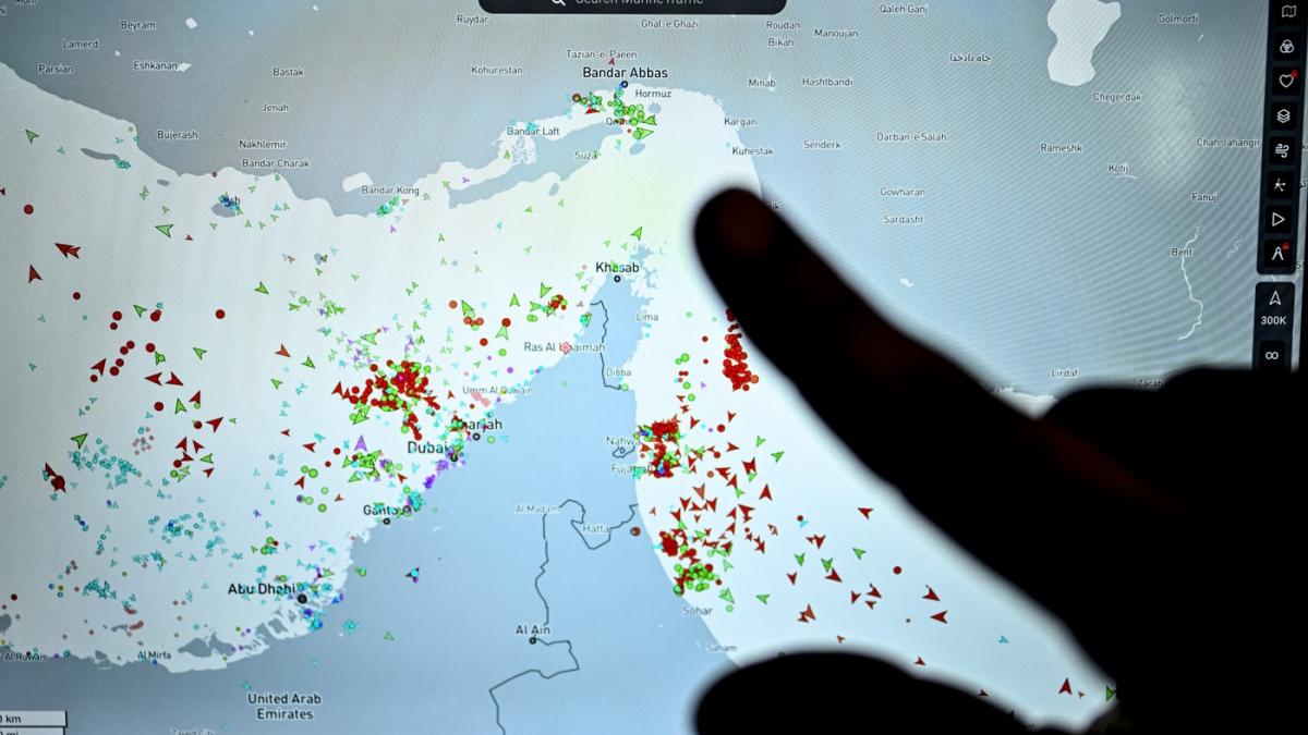 o persoana arata cu degetul pe un ecran catre traficul de nave din stramtoarea ormuz