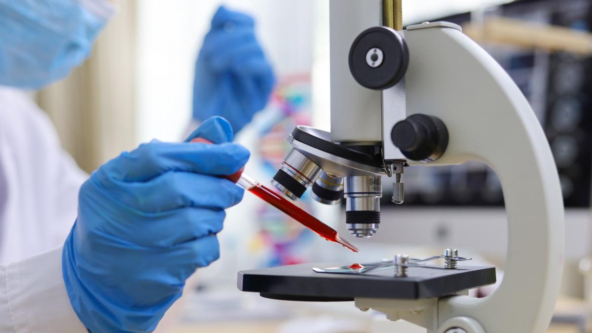 poza in care apare un om de știință care lucrează cu o probă de sânge în laborator