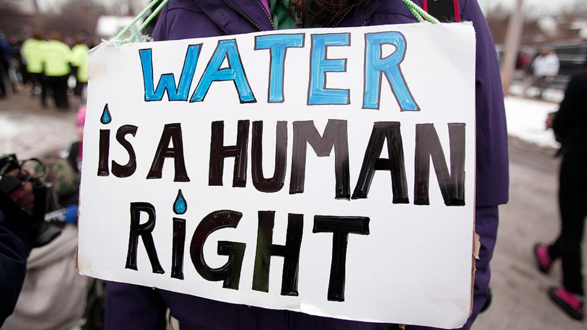 fata cu o pancarta la gat pe care scrie water is a human right