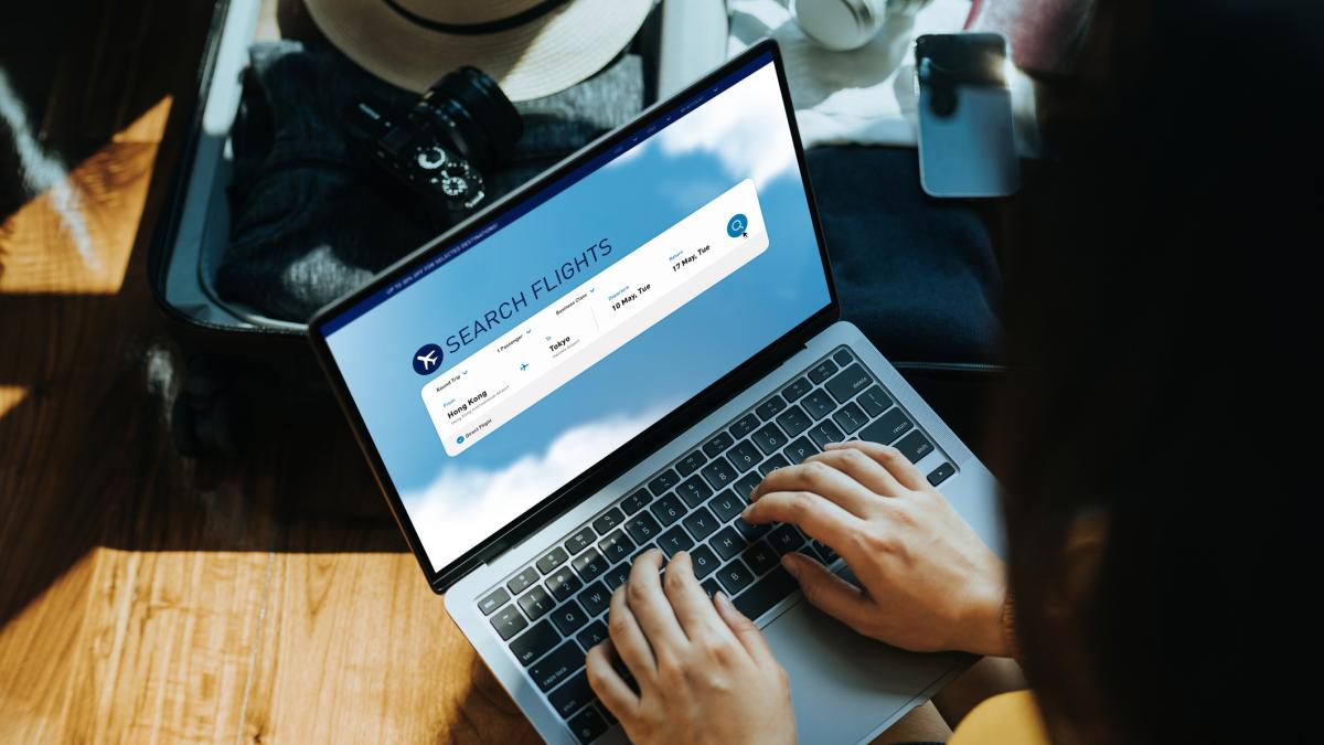 femeie rezerva bilet de avion pe laptop