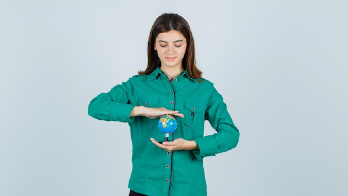 femeie care tine in mana globul pamantesc