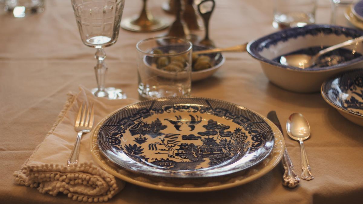 masa aranjata cu farfurii de portelan si tacamuri scumpe