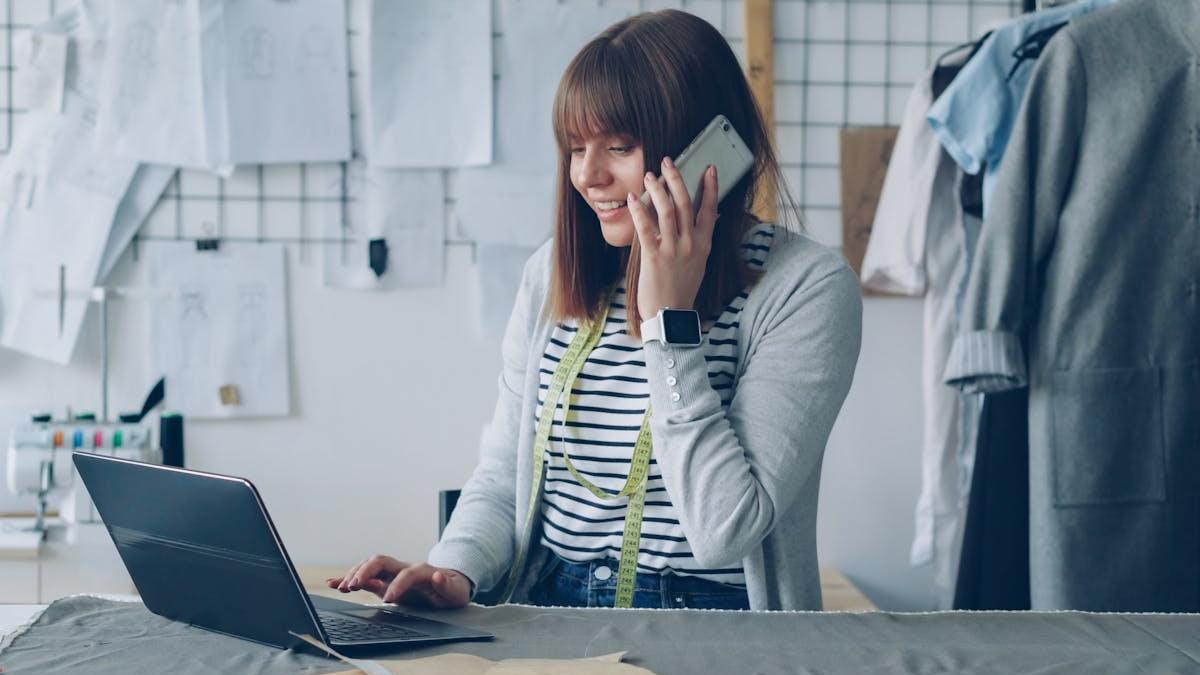 femeie lucrand la birou si vorbind la telefon