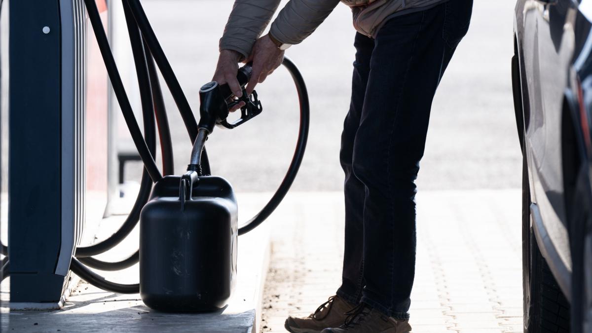 un sofer unple un recipient din plastic cu carburanti