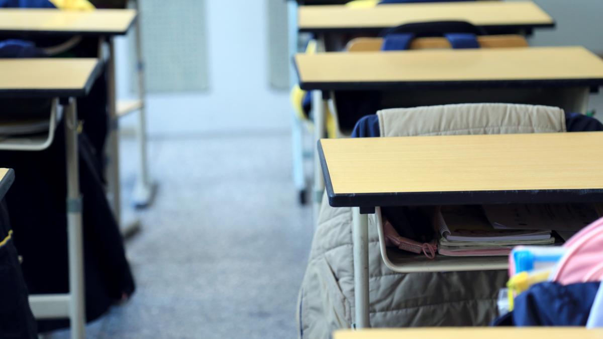 o sala de clasa cu banci si ghiozdane in banci