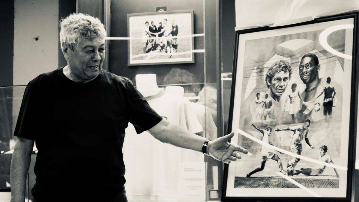 mircea lucescu aratand spre un tablou