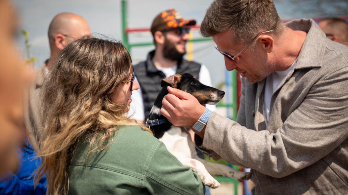 oameni cu catel in brate