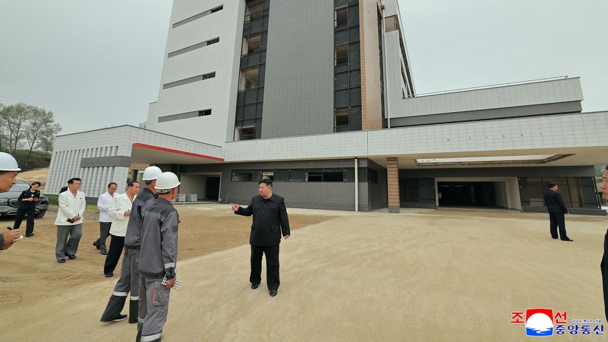 kim jopng un vorbeste in fata unei cladiri cu niste muncitori