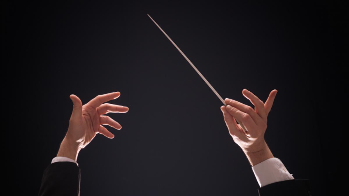 mainile unui dirijor cu bagheta 