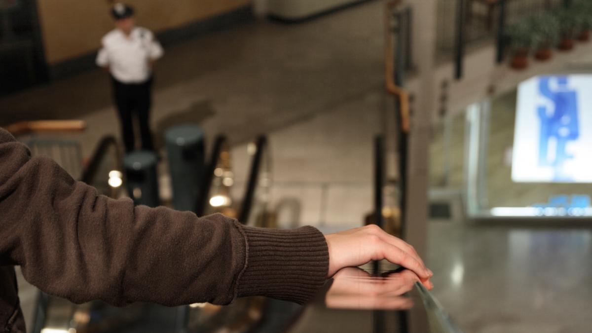 femeie scari rulante centru comercial paznic magazine