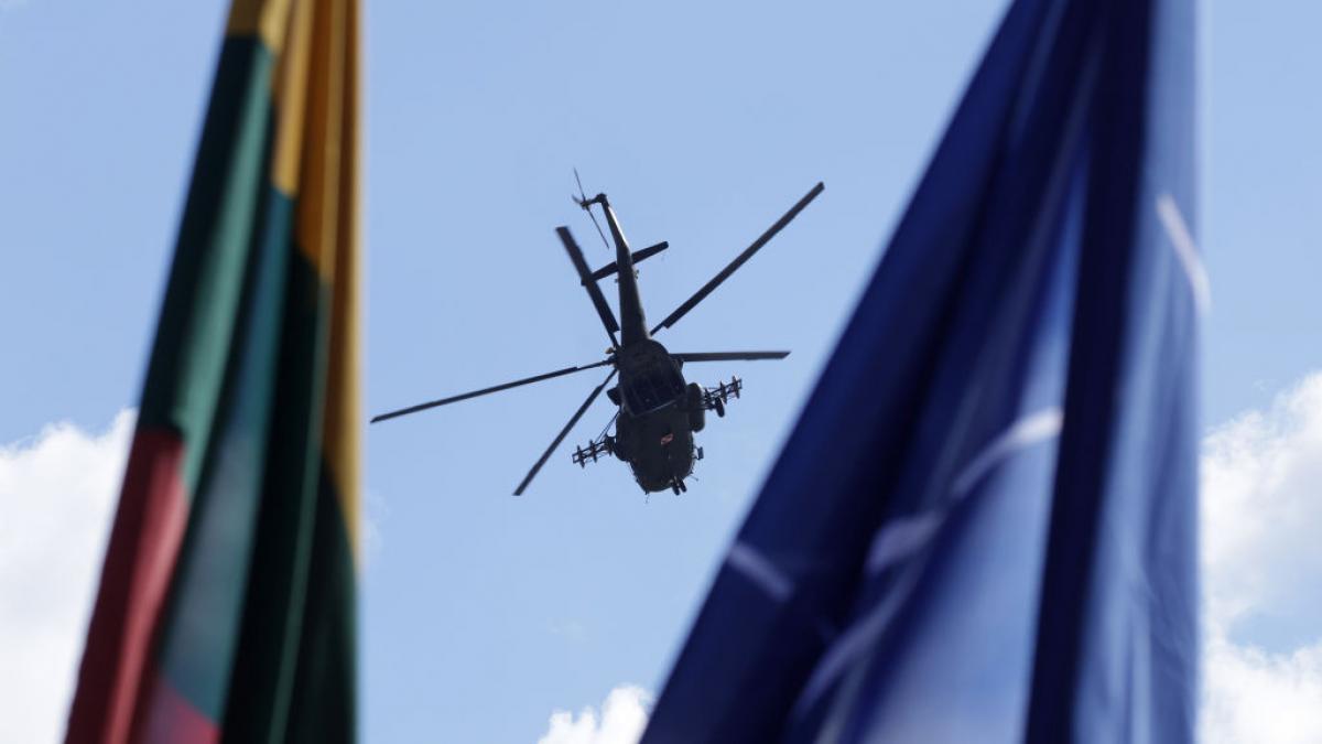 elicopter în aer văzut între steagurile lituaniei și nato