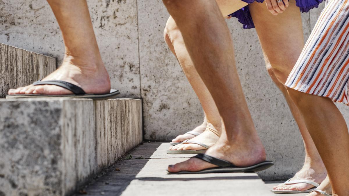 picioare care urca scarile incaltate in slapi