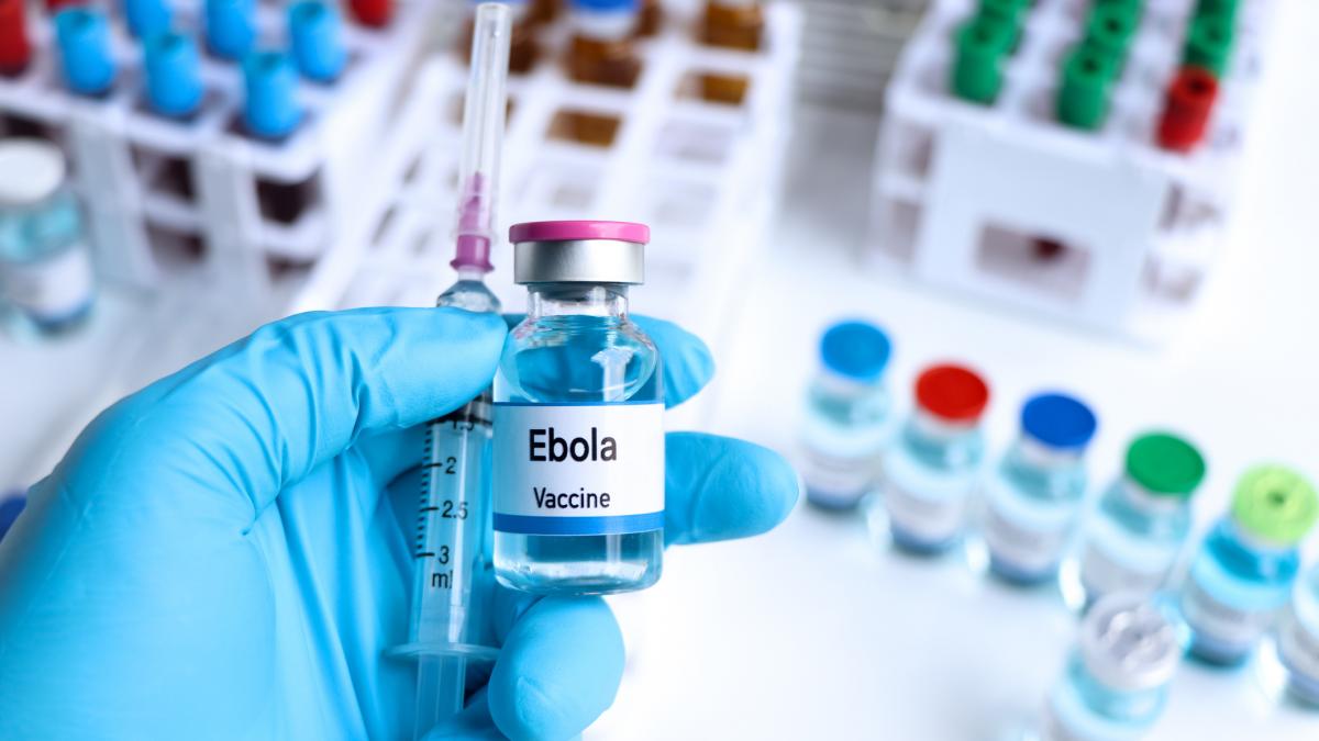 poza in care apare mana unui cercetator in timp ce tine o seringa si o sticla in care s-ar afla un vaccin pentru Ebola