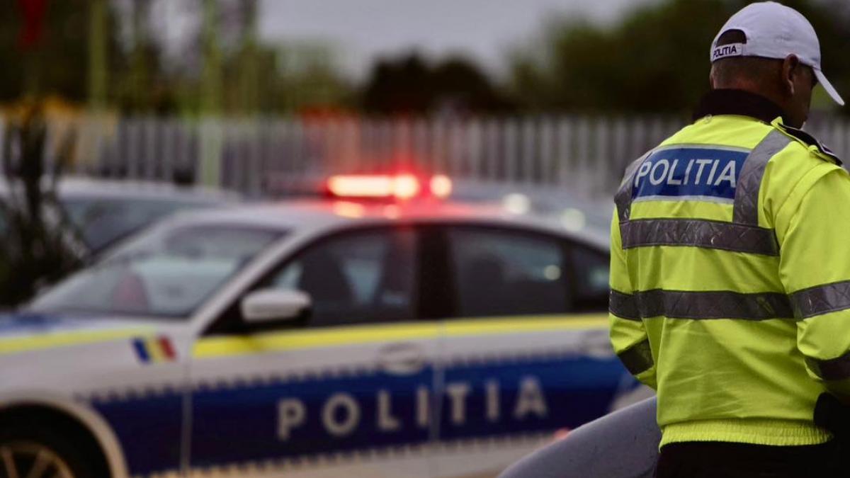 poza in care apare o masina a politiei si un politist cu spatele, nu i se vede fata