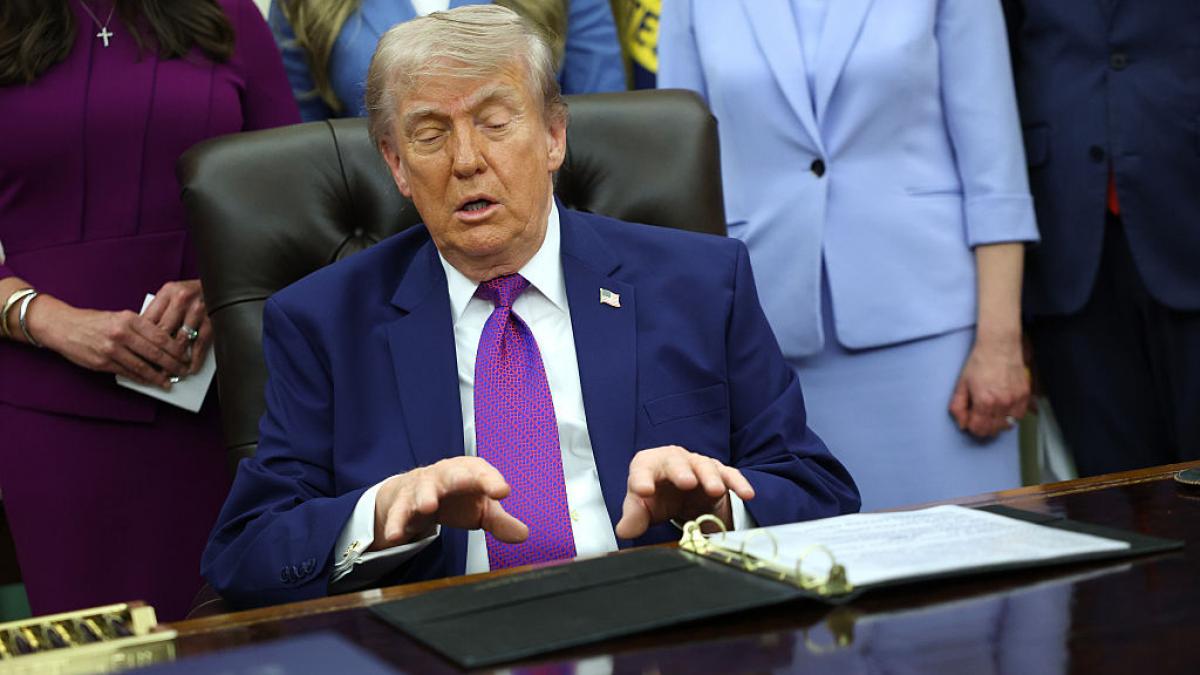 Donald Trump la birou cu un clipboard în față