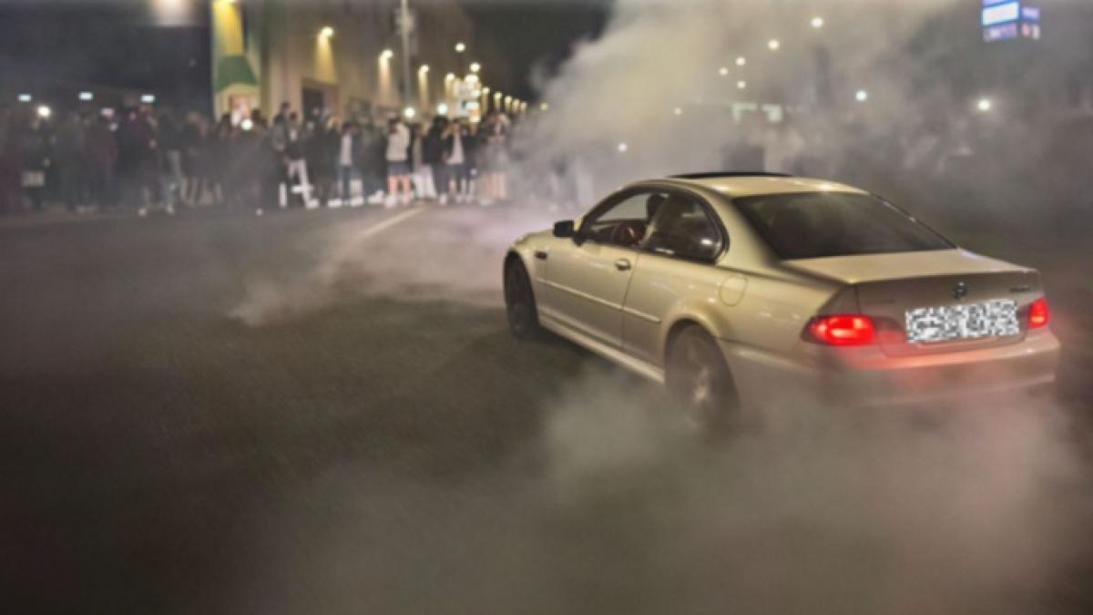 masina care face drift si multi oameni in jurul ei