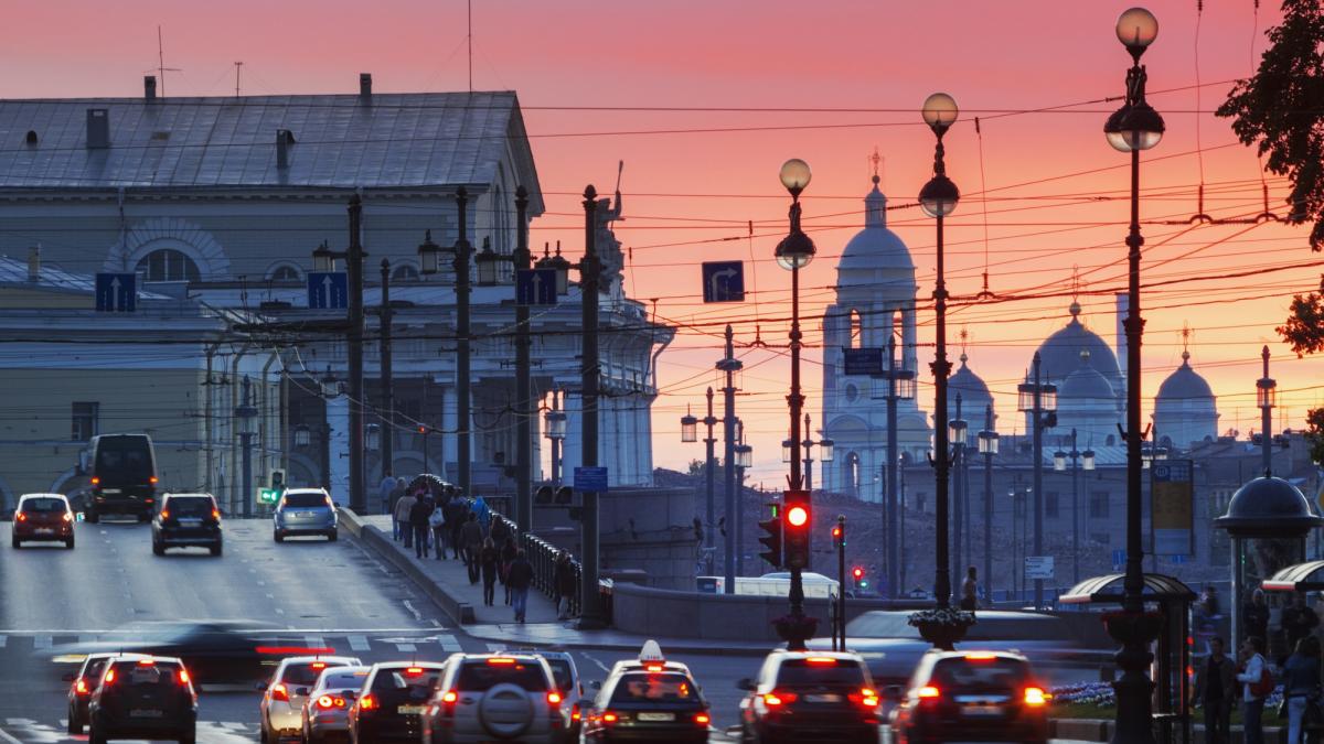 poza in care apare un bulevad cu masini din orasul Sankt Petersburg şi se vede o biserică în zare