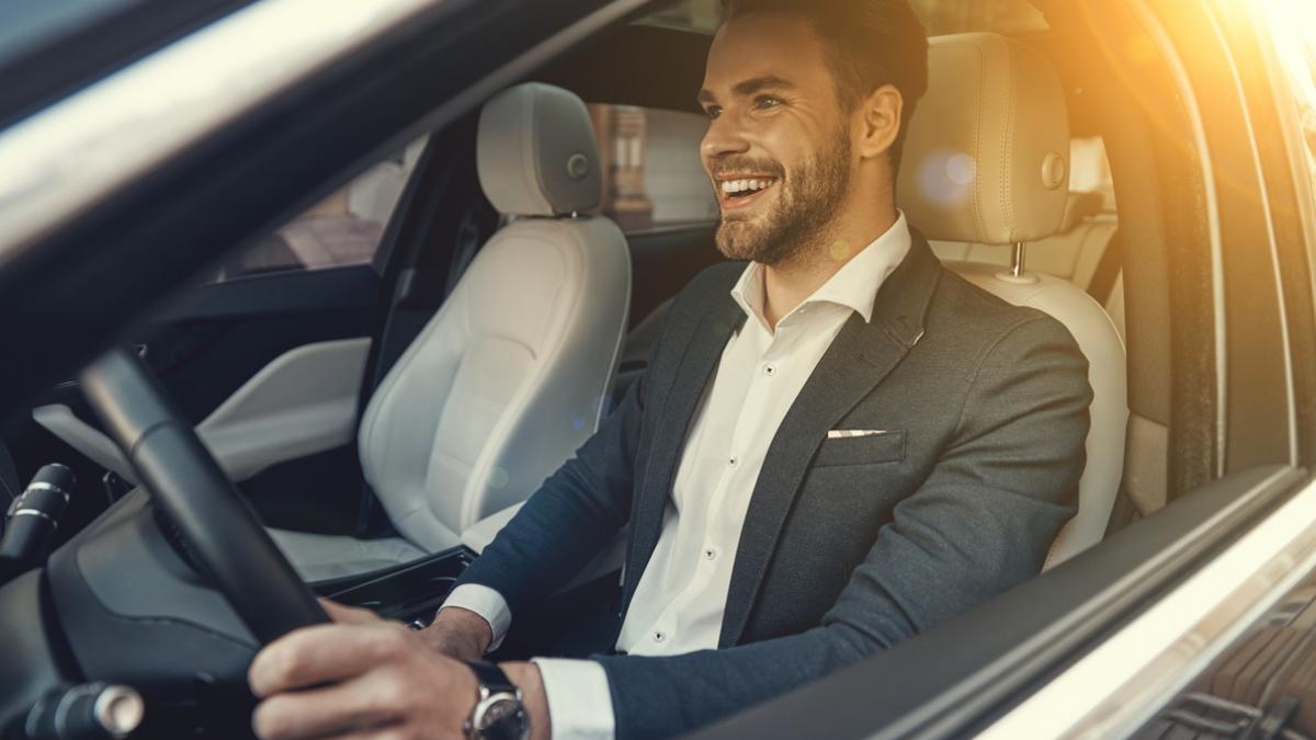 rent a car barbat tanar in costum la volanul unei masini 