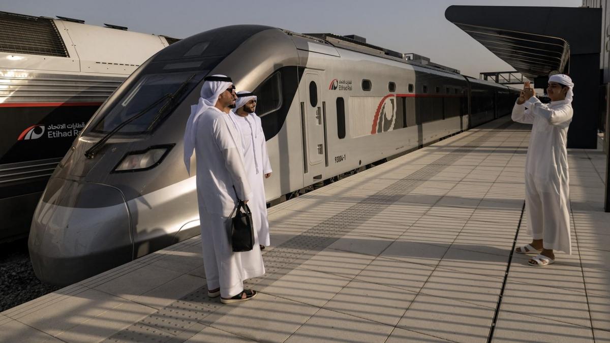 doua persoane araba se fotografiaza in fata primului tren de pasageri din emiratele arabe