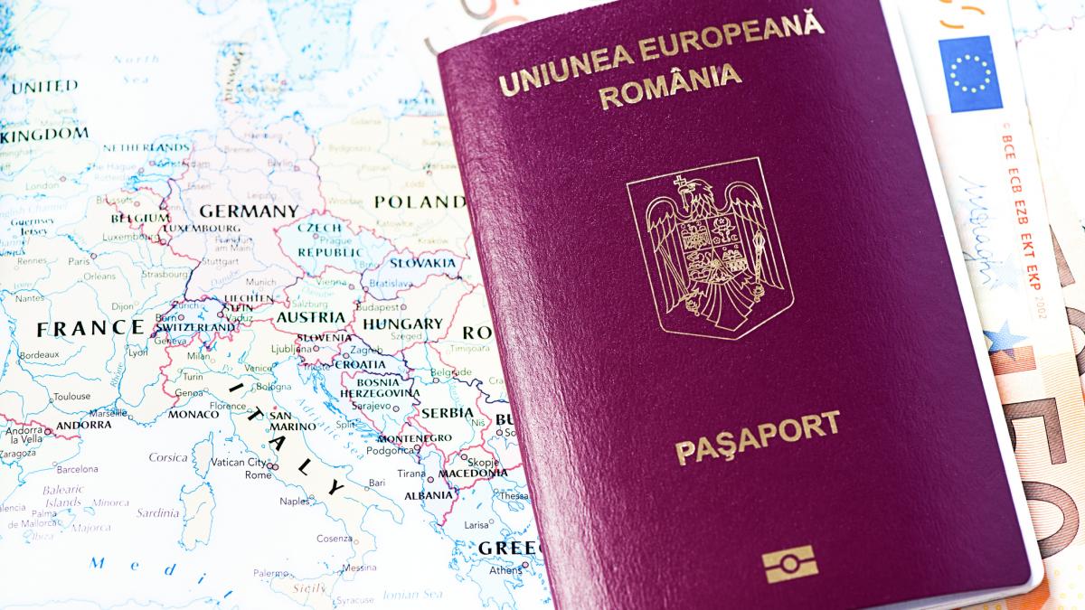poza cu un paşaport, aşezat pe o hartă a lumii, iar în el se află mai multe bancnote de euro