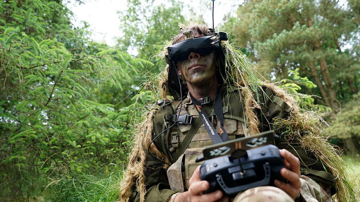 soldat cu camuflaj pilotează o dronă