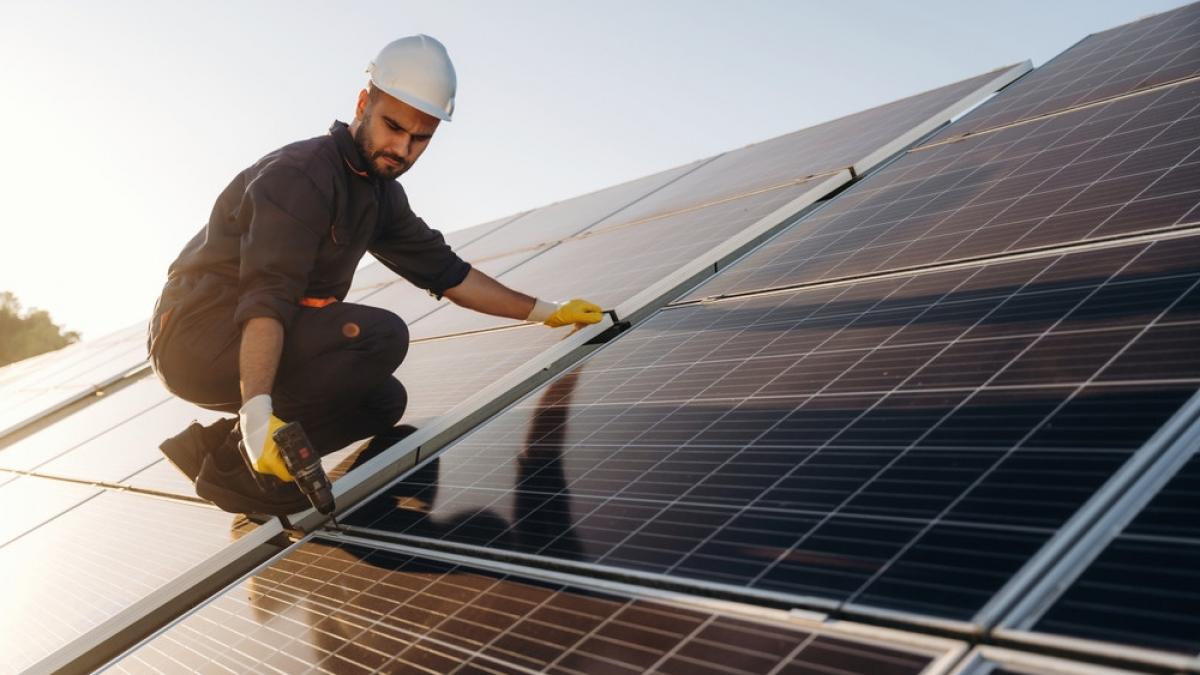 barbat-inginer-lucrand-pe-acoperisul-casei-la-panouri-fotovoltaice